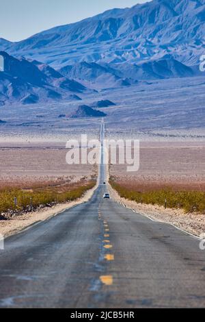 Long road going up into desert mountains Stock Photo