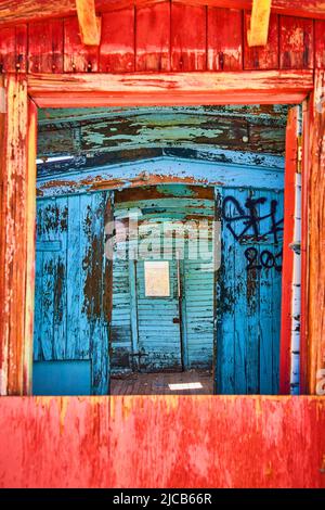 Layers of colorful carts inside abandoned train in desert with red and blue Stock Photo
