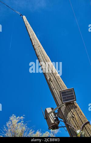 Looking up telephone pole with camera and solar panel Stock Photo