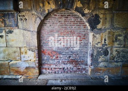 Mysterious stone archway filled in by brick Stock Photo