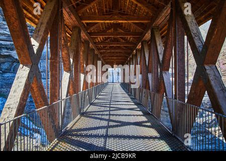 Looking down long walking bridge of wood and metal Stock Photo