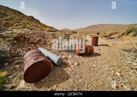Rusted metal barrels outside of abandoned mine in Death Valley desert Stock Photo