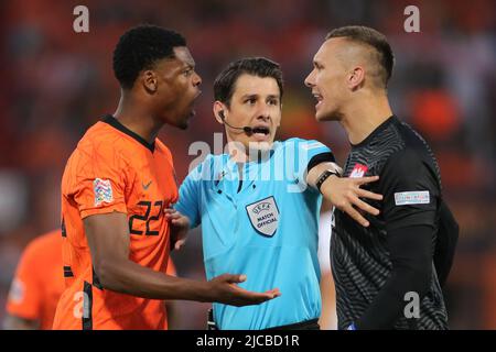 Rotterdam, Netherlands. 11th June, 2022. Goalkeeper Lukasz Skorupski (R) of Poland clashes with Denzel Dumfries (L) of Netherlands as referee Halil Umut Meler intervenes during the UEFA Nations League league A football match between the Netherlands and Poland in Rotterdam, the Netherlands, on June 11, 2022. Credit: Zheng Huansong/Xinhua/Alamy Live News Stock Photo