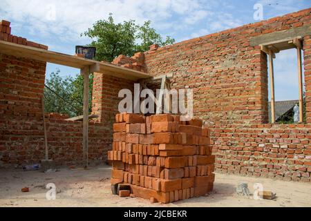 Unfinished house of brick, still under construction,unfinished brick house with a view from the inside of the room Stock Photo