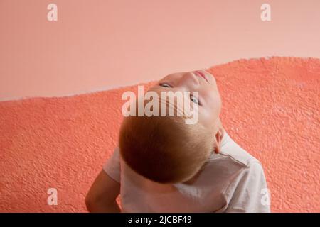 child turned his head to the back and looks up Stock Photo