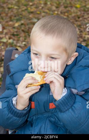 two hands holding a child eats bread Stock Photo