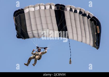 May 22, 2022 - Yokota Air Base, Japan - U.S. Air Force Tech. Sgt. Seth Sarrett, 374th Operations Support Squadron survival, evasion, resistance and escape specialist, descends from a USAF C-130J Super Hercules assigned to the 36th Airlift Squadron during the Japanese-American Friendship Festival at Yokota Air Base, Japan, May 22, 2022. A six member team comprised of U.S. Air Force and JGSDF paratroopers, conducted a military free fall demonstration to show their capabilities during the festival. During the two-day festival, more than 110,000 attendees came to Yokota to experience the event. Th Stock Photo