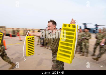 Cannon Air Force Base, New Mexico, USA. 20th May, 2022. U.S. Airmen assigned to the 27th Special Operations Maintenance Group compete in a wheel chock relay race during Aviation Maintenance Technician day at Cannon Air Force Base, N.M., May 20, 2022. AMT day is an annual celebration that highlights the accomplishments of aviation maintenance professionals, as well as Charles Edward Taylor, who built the engine for the Wright Brothers. Credit: U.S. AAir Force/ZUMA Press Wire Service/ZUMAPRESS.com/Alamy Live News Stock Photo