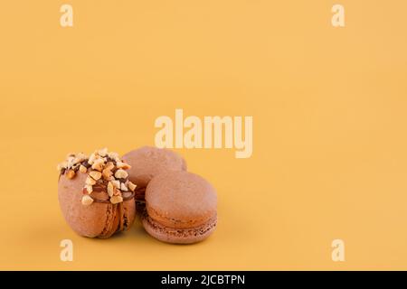 Several macaroons of various flavours on yellow background.  Space for text Stock Photo