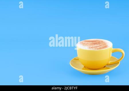 yellow cup of coffee   on blue background Space for text Stock Photo