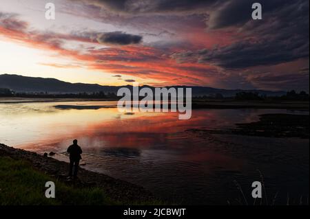 Dark clouds gather during sunset overlooking the sea Stock Photo
