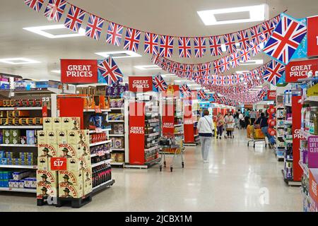 Sainsburys supermarket shoppers & interior view of union jack flags above  shopping aisle celebrates Queen Elizabeth Platinum Jubilee Essex England UK Stock Photo