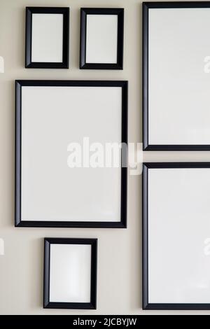 Different size framed photos hanging on the gray wall. Mockup. Stock Photo