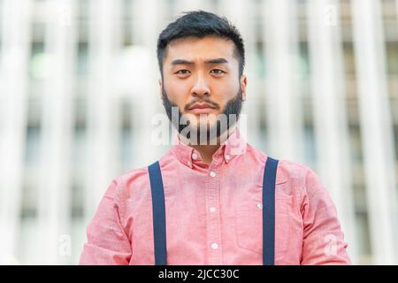 Close up portrait of a serious asian man outside Stock Photo