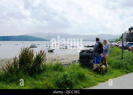 Porthmadog, Wales. Quaint Borth Y Gest village. Tourists look over the picturesque small bay on a summer day.  Landscape aspect shot with copy space. Stock Photo