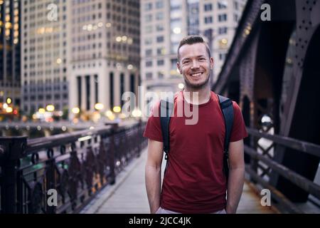 Front view of smiling man looking at camera on evening city street. Stock Photo