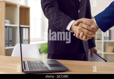 Two male entrepreneurs meet in the office, make a business deal and exchange handshakes Stock Photo