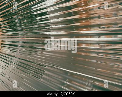 Plastic wrap background. Crumpled wrinkled plastic cellophane. Reflecting light and shadow on creases and folds in plastic surface. Texture overlay Stock Photo