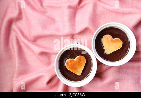 Pair of Chocolate Mousse Pastries with Heart Shaped Chiffon Cakes on Pink Drapery Cloth Stock Photo