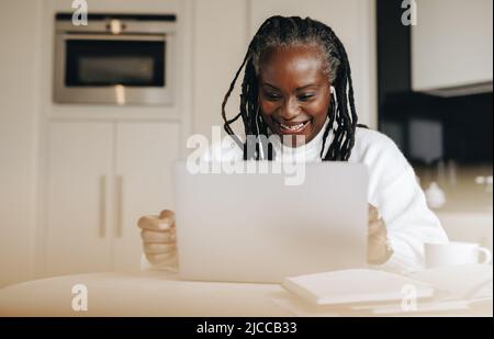 Happy mature businesswoman having a video call in her home office. Cheerful senior businesswoman having a virtual meeting with her colleagues while wo Stock Photo