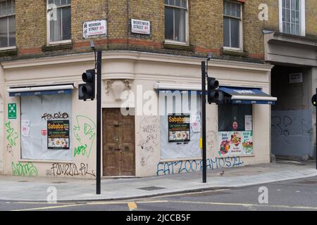 Pedestrians outside closed down and boarded up sandwich shop, Mortimer Street, City of Westminster, London, UK.  5 Jun 2022 Stock Photo