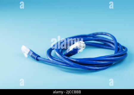 Blue UTP Internet Cable - Isolated on a blue background Ethernet Cord Stock Photo