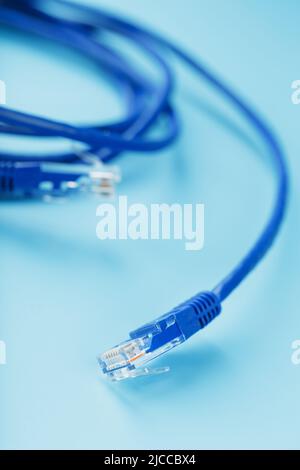 Blue Ethernet Cable Connectors Patch cord cord close-up isolated on a blue background with free space Stock Photo