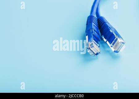 Blue UTP Internet Cable - Isolated on a blue background Ethernet Cord Stock Photo