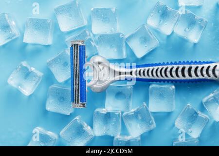 Blue shaving machines in a row on a blue background with ice cubes. The concept of cleanliness and frosty freshness Stock Photo