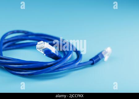 Blue Ethernet Cable Connectors Patch cord cord close-up isolated on a blue background with free space Stock Photo