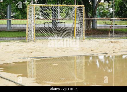 reflection of goal frame on water in sand handball field in park Stock Photo