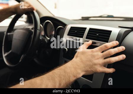 Male Driver Pushing Button On Control Panel Driving Car, Closeup Stock Photo