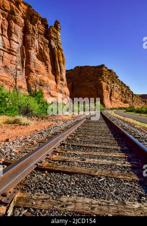 Railroad at the bottom of a canyon next to Layered Geological ...