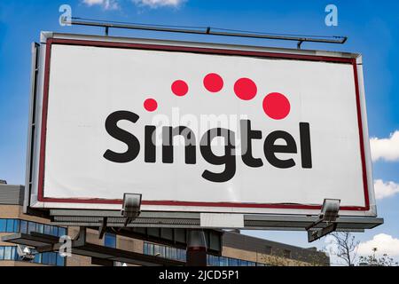 POZNAN, POL - MAY 1, 2022: Advertisement billboard displaying logo of Singtel, a Singaporean telecommunications conglomerate Stock Photo