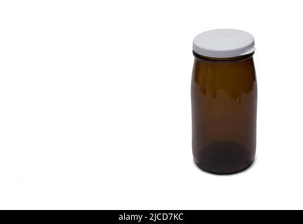 Close up of a milk or yogurt glass bottles in brown color with plastic lid cap on the top against white background offering copy space Stock Photo