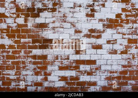 Old distressed brickwall with worn out white plaster, grunge shabby wall background or texture Stock Photo