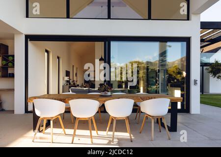 View of luxurious modern house exterior with dining space and garden Stock Photo