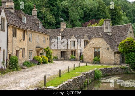 honey coloured Cotswold stone houses and Bybrook river in Castle Combe Wiltshire England often named as the prettiest village in England Stock Photo