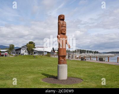 A view of an indigenous carved totem pole and the harbour and marina in Sidney, British Columbia on Vancouver Island, Canada. Stock Photo