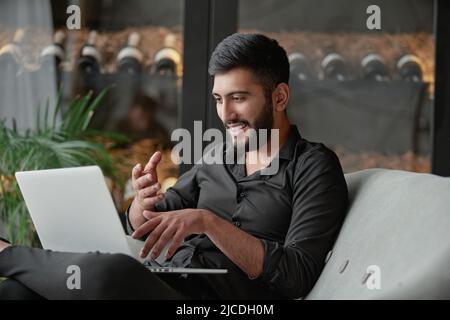 satisfied wine shop owner looking at his laptop screen . Stock Photo