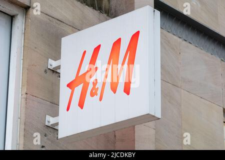 H&M Market Street Manchester, fashion store selling clothing and accessories for male and female. Isolated sign on wall. England, UK Stock Photo
