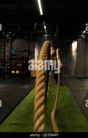 Rope training man warehouse fitness gym muscular exercising exercise workout, concept strong heavy from body from sportsman sport, muscle wave Stock Photo
