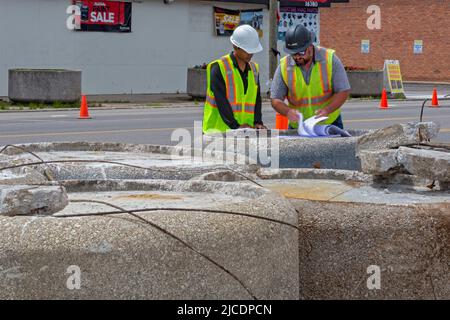 Detroit, Michigan - Construction workers look over plans for streetscape improvements on East Warren Avenue where there are many empty storefronts. Th Stock Photo