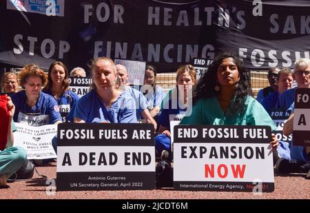 London, UK. 11th June 2022. Protesters outside the Treasury. Extinction Rebellion doctors, nurses and other health professionals gathered for a protest in Westminster to demand an end to fossil fuel investments Stock Photo