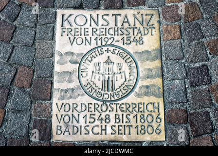 Cobblestone pavement in Constance (Konstanz), Germany. Metal plate on road in old town of Constance. Translation: Constance is free city from 1192, pa Stock Photo