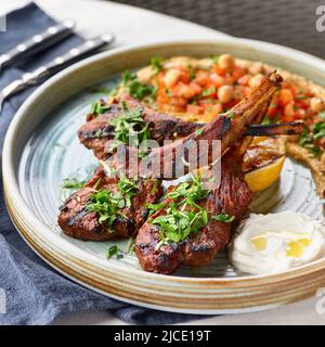 Raw rack of lamb fried with aromatic with hummus and yogurt Stock Photo