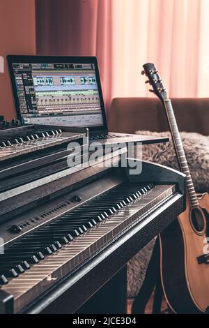 Electronic piano and guitar in room interior. Stock Photo