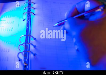 businessman making notes in his diary with blue selective focus Stock Photo