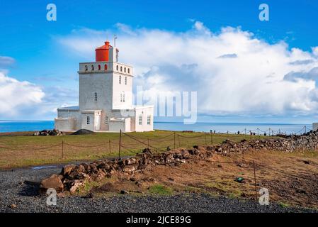 Scenic view of Dyrholaey lighthouse on cliff with sea in background against sky Stock Photo