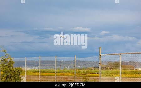 Light plane landing on the runway on the airfield. Small airplane in the sky, student is learning how to land on the ground. Travel photo, nobody, cop Stock Photo